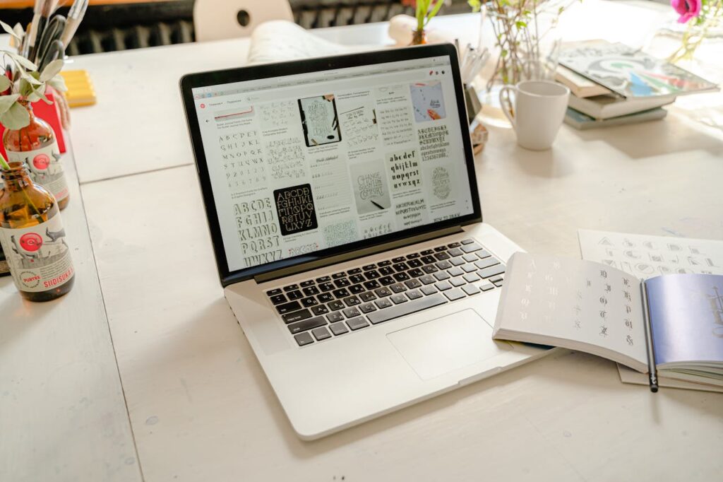 Laptop Near the Calligraphy Lettering Book